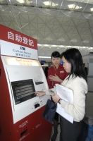 西北航空与国泰航空职员示范使用自助登记机。
